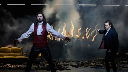 Szenenfoto der Stücks "Don Giovanni" an der Oper Dortmund: Denis Velev, Ks. Morgan Moody, Artyom Wasnetsov und Mitglieder des Opernchors Theater Dortmund im Hintergrund.