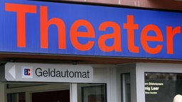 Archivaufnahme von 2010: Ein Hinweisschild für einen Geldautomaten hängt an der Außenfassade eines Theaters.