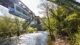 Schwebebahn über der Wupper im Gegenlicht.