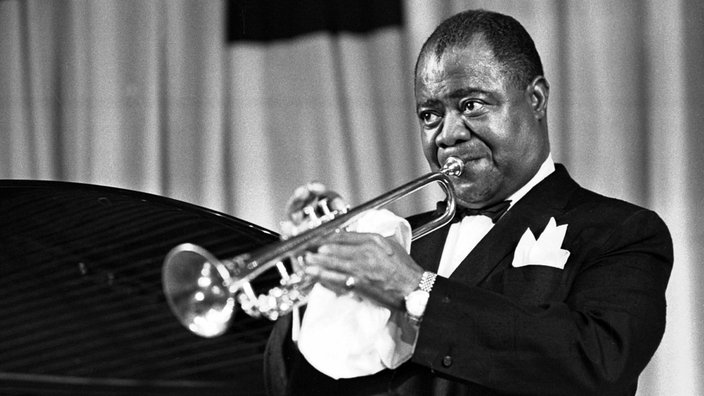 Eine Schwarz-Weiße Aufnahme von dem amerikanischen Jazztrompeter Louis Armstrong in Prag.