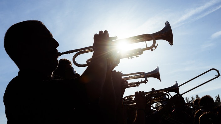 Bläsergruppe spielt draußen im Sonnenlicht