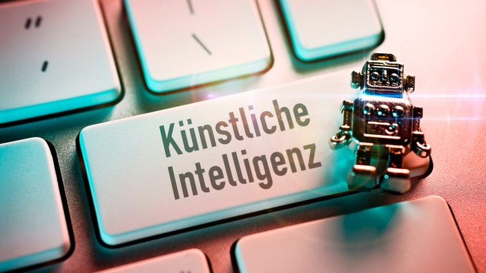 Miniatur-Roboter auf einer Computertaste mit der Aufschrift Künstliche Intelligenz.