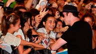 John Travolta winkt einer großen Menge von Fans beim Filmfestival San Sebastian 2012.