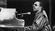 Stevie Wonder sitzt 1984 bei einem Konzert in Berlin am Flügel