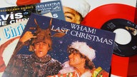 Plattencover verschiedener Weihnachtshits, im Vordergrund Wham! mit "Last Christmas"