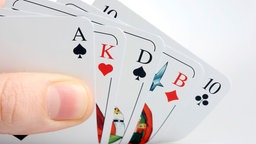 Hand hält Spielkarten