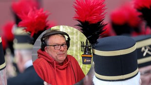 Moderator Joachim "Auge" Augner sitzt im WDR 4-Studio, im Hintergrund Bergleuter mit der typischen Steiger-Kopfbedeckung