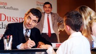 Rowan Atkinson signiert Buch für Fan