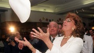 Die italienische Filmdiva Sophia Loren zeigt bei der Eröffnung des Sommerschlußverkaufs am 07.07.1999 im Londoner Luxus-Kaufhaus «Harrods», wie ein Pizza-Teig in die richtige Form gebracht wird.