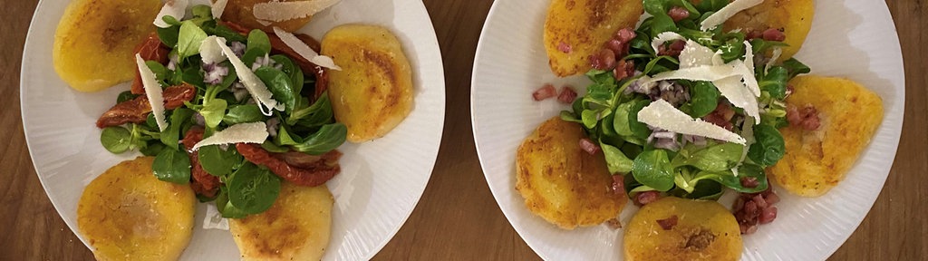 Gebratene Kartoffelklöße auf Feldsalat