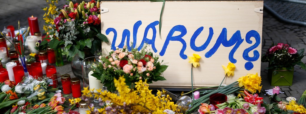 08.04.2018, Nordrhein-Westfalen, Münster: Ein Schild mit der Aufschrift "Warum?" liegt neben Blumen am Tatort der Amokfahrt von Münster.