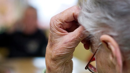 Frau, die sich den Kopf mit der Hand abstützt