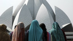 Angehörige der Religionsgemeinschaft der Bahai stehen vor dem Lotus Tempel der Bahai in Dehli, Indien.