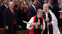 Präsident Donald Trump sieht zu, wie Bischöfin Mariann Edgar Budde zum nationalen Gebetsgottesdienst in der Washington National Cathedral kommt.