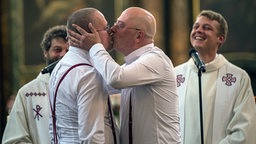 Sven Kretschmer (l) und Tim Schmidt-Kretschmer küssen sich bei der Trauung am 12.08.2016 in der Marienkirche in Berlin. Nach Angaben der Evangelischen Kirche Berlin-Brandenburg-schlesische Oberlausitz soll es sich dabei um die erste gleichgeschlechtliche Trauung der Landeskirche handeln.