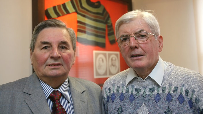 Die Brüder Manfred und Helmut Dutschke (v. l.) stehen am Freitag (07.03.2008) im Heimatmuseum von Luckenwalde (Brandenburg) vor einem Glasrahmen mit dem berühmten Strick-Pullover von ihrem Bruder. Rudi Dutschke