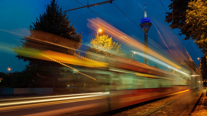 Lichtspuren von zwei Straßenbahnen bei Nacht, Düsseldorf