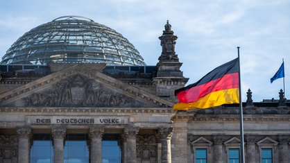 Vor dem Reichstagsgebäude weht die deutsche Flagge