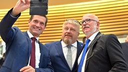 Die AfD-Abgeordneten Uwe Thrum, Jan Abicht und Jürgen Treutler, AfD-Abgeordneter und Alterspräsident, machen ein Selfie nach der Unterbrechung der konstituierenden Sitzung des Landtags