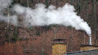 Ein qualmender, dampfender Schornstein auf einem Haus in Siegen.