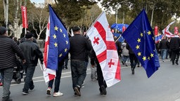 Menschen mit georgischen und EU-Fahnen. Demonstration in der georgischen Hauptstadt vor Parlamenswahl. 