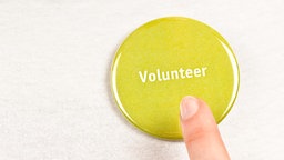 Ein Mensch zeigt auf einen Button "Volunteer"