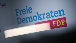 Der Schriftzug ·Freie Demokraten FDP· ist in der FDP-Bundesgeschäftsstelle hinter einer Lichtreflektion zu sehen.