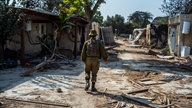 Ein israelischer Soldat geht an zerstörten Häusern im Kibbuz Kfar Aza vorbei.