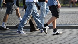 Symbolfoto: Ausschnitt von Jugendlichen in Jeans und Turnschuhen.