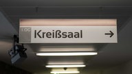 An der Decke eines Flurs hängt ein Schild mit der Aufschrift "Kreißsaal".