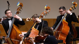 Fahnen der Ukraine stecken während eines Konzerts des Kyiv Symphony Orchestras im Dresdner Kulturpalast an den Instrumenten der Musiker. Archivbild: 13.01.2023