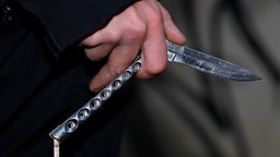 Eine Person hält ein Messer in der Hand. Symbolbild