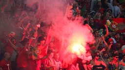 Fußballfans zünden Bengalos im Stadion. Symbolbild