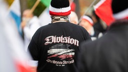 Mann mit schwarzem Pullover mit dem Aufdruck "Division Sachsen-Anhalt - Treu der Fahne" und eine schwarz-rot-weiße Mütze