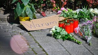 Blumen, Kerzen und ein Schild mit der Aufschrift "Warum" nach dem tödlichen Messerangriff in solingen (24.08.2024).