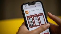Symbolbild: Smartphone-Display zeigt eine Seite des Onlineanbieters Temu.