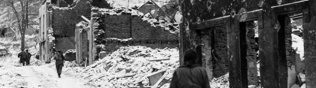 Soldaten auf den Straßen des verschneiten und zerbombten Houffalize, Belgien, im Januar 1945