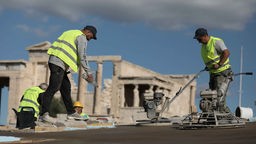 Arbeiter auf Griechenlands Hauptsehenswürdigkeit, der Akropolis in Athen, errichten einen Weg, um Rollstuhlfahrern, älteren Bürgern und Personen mit Mobilitätsproblemen den barrierefreien Zugang zu den Denkmälern der Akropolis in Athen zu ermöglichen