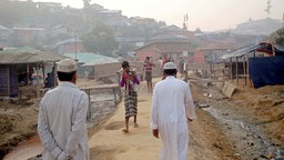 Männer und Jungen laufen entlang eines Weges im Balukhali Camp in Bangladesch.