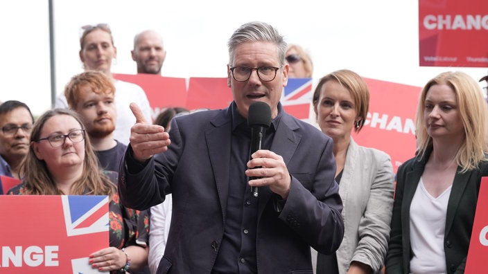 Keir Starmer ist bei einem Wahlkampfauftritt umringt von Menschen, die gleiche Schilder mit der Aufschrift "CHANGE" tragen.