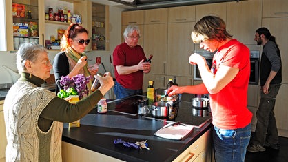 Symbolbild: Mehrere Bewohner beim gemeinsamen Kochen in der Küche der Loungeetage des Mehr-Generationenhauses "Generationen-Kult-Haus" in Essen.