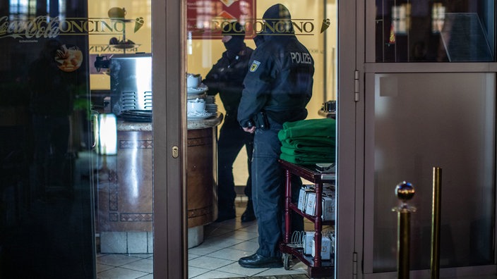 Polizisten stehen im Rahmen einer Razzia gegen die italienische Mafia in einem Café in Duisburg.