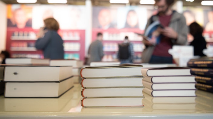 Archivaufnahme von 2023: Ausgestellte Bücher auf der Frankfurter Buchmesse, im Hintergrund Messebesucher.