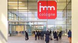 Archivaufnahme: Eingangs Bereicht der internationale Möbelmesse in Köln mit Besucherinnen und dem Logo "imm Cologne".