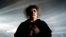 "The Cure"-Frontmann Robert Smith in vernebeltem Scheinwerferlicht auf der Bühne, 2022.