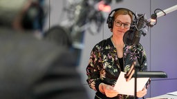 Marija Bakker im Studio mit Kopfhörern auf vor dem Mikrofon