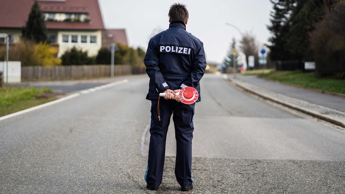 Polizist steht auf einer menschenleeren Straße