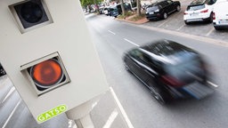 Ein kombiniertes Gerät für die Rotlicht- und Geschwindigkeitsmessung steht an einer Straße.