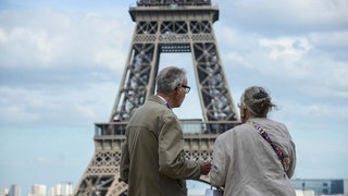 Renter stehen vor dem Eifelturm in Paris. 