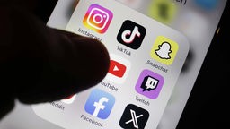 Detailansicht eines Smartphones mit Apps für soziale Medien: Facebook, X, Instagram, Tik Tok, Snapchat, Pinterest und YouTube sind zu sehen.